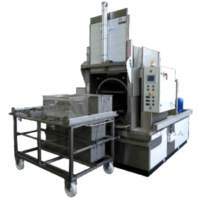 corner view front open Platinum series P1200 rotary immersion parts washer with wash cage resting out front on loading table.